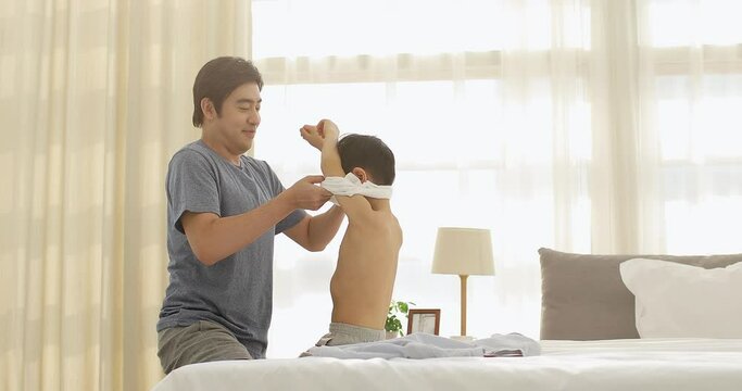 Father helping son getting dressed,4K