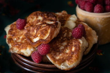 Homemade puffy ruddy pancakes with raspberries.