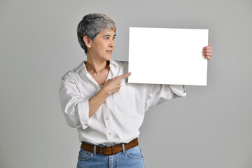 Attractive middle aged Asian woman showing blank signboard isolated on white background