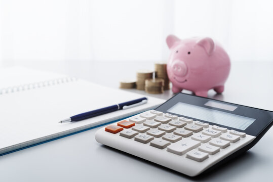 Saving money and household finance management.  Calculator and piggy bank.