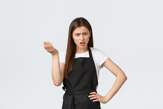 Grocery Store Employees, Small Business And Coffee Shops Concept. Frustrated Annoyed Barista In Black Apron Complaining, Looking Concerned And Bothered, Having Argument