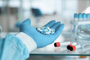 Scientist hands holding Omega 3 capsule in labcoat, doing experiments in lab