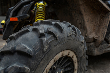 Fototapeta na wymiar Dirty ATV wheel. Speed, extreme and adrenaline. Close-up.