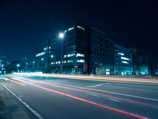 夜の都会の道路と車のライトの光跡