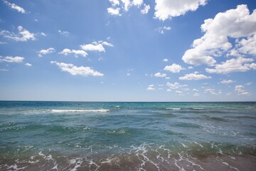 A summer vacation background of a tropical beach and blue sea and white clouds