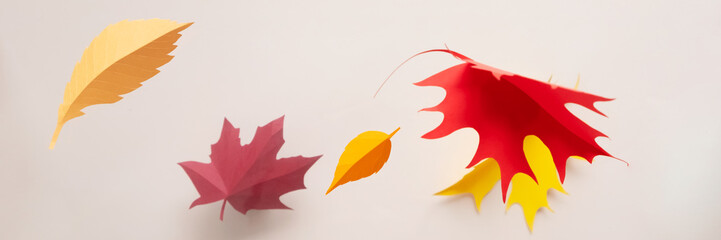 Autumn leaves cut from paper on beige background. Hello, autumn concept.