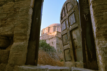 View through a stone gate shows an ottoman mosque built in the medieval city of Rhodes.