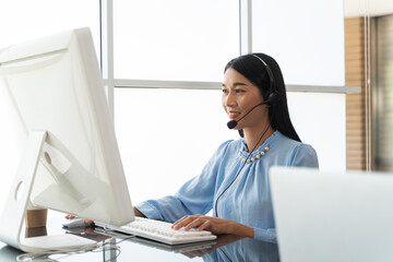 Woman professional call center employees Talking to customers with headsets. Friendly operator or helpdesk agent are assisting remote customers and consulting client by remortly. Soft Focus.