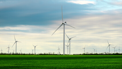 Wind turbines generating electricity with cloudy sky - energy conservation concept