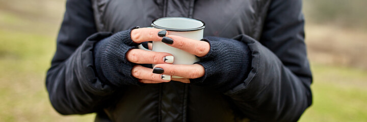 Banner of Woman in red hat and scarf, drinking tea from metal cup outdoor