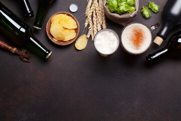 Lager beer mug, bottles, hops and wheat on old stone table