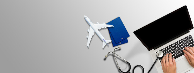 Mock up image of medical stethoscope, passport, laptop computer, air plane isolated on grey background.Trip, travel and insurance concept.
