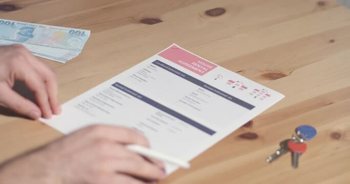Renter reading and signing agreement get keys to new home