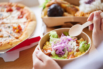 フードデリバリー食を食べる女性の手元