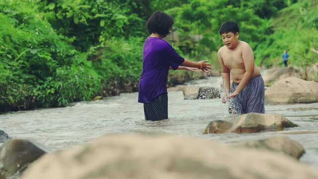 Children playing with friends in the river in countryside, Boys and girls smiling and happiness playing water at the countryside in Thailand.