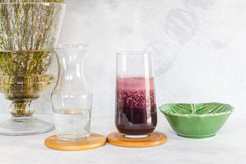 Mesa decorada para servir agua y zumo de remolacha con hermosa decoración de flores en un lado sobre fondo blanco rústico aislado.