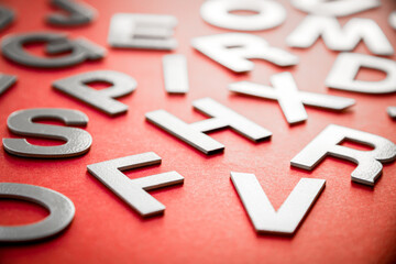 Mixed letters pile close up view photo. Red background