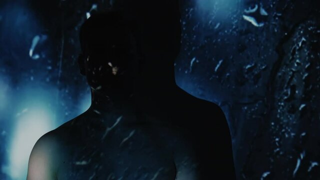Depression disorder. Sadness sorrow. Melancholy mood. Loneliness crisis. Man silhouette in rain blue light bokeh glass raindrops fall double exposure projection dark free space.