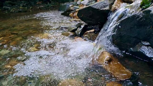 Slow motion of mountain river flowing over rocks