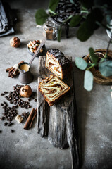 Sweet walnut roll on a gray background and a wooden stand.