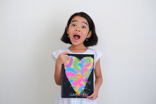 Asian little girl showing colorful hand drawing love heart shape with excited face expression