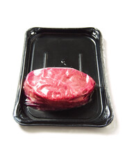 One fresh raw piece of fillet steak on a black plastic tray and a red heart. Love meat theme. Butcher product. High quality beef cut. White isolated background. Meat industry