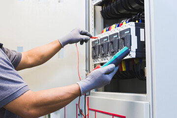 Electrical engineer tests the operation of the electric control cabinet on a regular basis for...