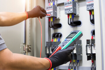 Electrical engineer tests the operation of the electric control cabinet on a regular basis for...