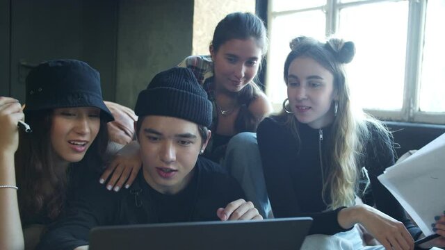 Group of teenagers searching for information online via laptop 