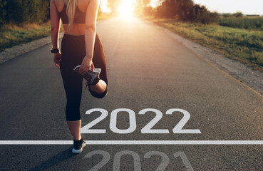 Naklejka na ściany i meble Young sporty girl waiting to start the new year 2022. New plans, objectives and visions for the next year.
