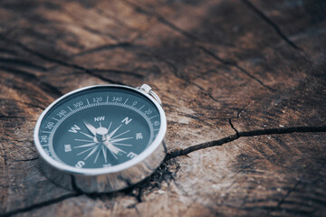 Magnetic compass on old brown wood. Vintage still life. Sailing accessories. Travel, navigation,...