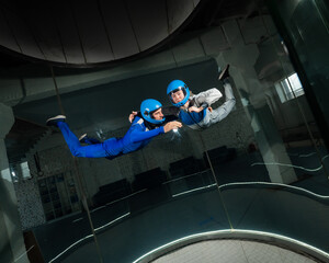 A man and a woman enjoy flying together in a wind tunnel. Free fall simulator