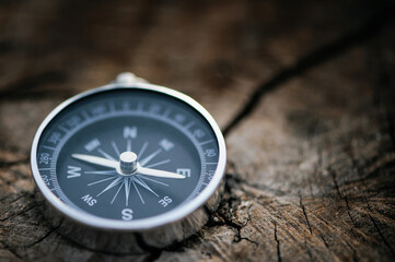 Fototapeta na wymiar Classic compass on a wooden vintage with a green background. compass for a symbol of tourism with compass, travel with a compass, life direction concept.
