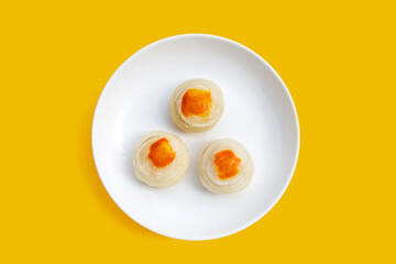 Chinese pastry in white plate on yellow background.