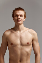 Fototapeta premium Young swimmer in excellent physical shape, on a gray background with copy space, call for sports, advertising banner