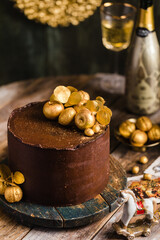 Chocolate cake with gold decor champagne behind rustic style