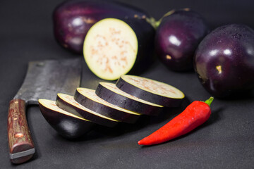 Red chili pepper on handmade knife and sliced eggplants