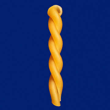 Close up uncooked gemelli pasta noodle on blue background
