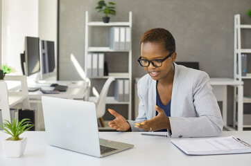 Black woman holding webinar or giving online business consultation to client. Female entrepreneur...