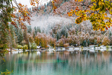 Between autumn and winter. Warm and cold reflections of snow on Lake Fusine.