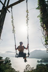 A girl rides on a swing with a gorgeous view of the valley, Bali.