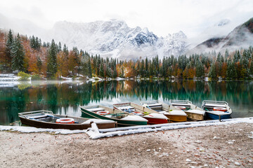 Between autumn and winter. Warm and cold reflections of snow on Lake Fusine.