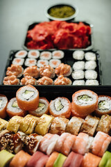 Food delivery. Set of sushi rolls with fish, cheese and sauces. Japanese traditional food. Top view.
