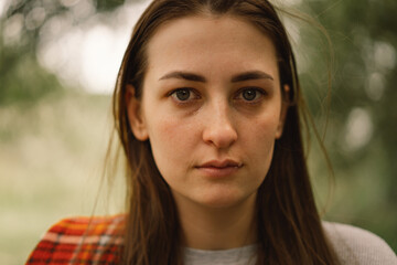Depressed young woman in a outdoors. The girl is crying. Woman without make-up. Negative human...
