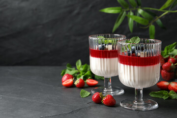 Delicious panna cotta with fruit coulis and fresh berries on dark grey table. Space for text