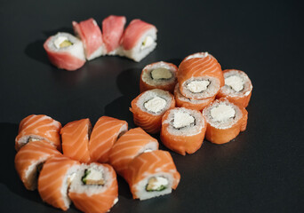 Sushi roll (Philadelphia) with salmon, smoked eel, avocado, cream cheese on black background. Sushi menu.
