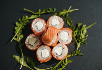 Sushi roll (Philadelphia) with salmon, smoked eel, avocado, cream cheese on black background. Sushi menu. Japanese food.