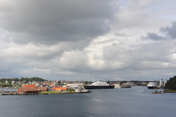 Fototapeta premium Harbour in Stavanger, Norway on a cloudy day with a suspension bridge, boats and ferries in the North Sea
