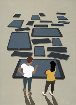 Couple looking at variety of smart phones and digital tablets
