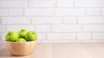 Ripe green apples in a wooden bowl on  a table. Useful fruits on wooden background. Top view with copy spac